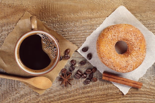 Gustosa ciambella e tazza di caffè caldo sul vecchio tavolo di legno, vista dall'alto