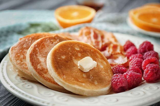 Gustosa colazione con frittelle pancetta e lampone sulla piastra da vicino