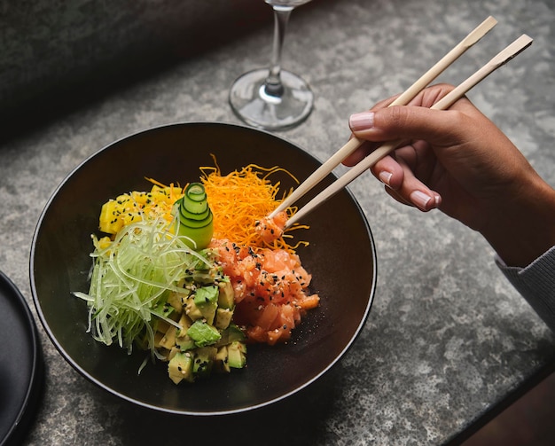 Gustosa e appetitosa poke bowl con insalata di riso al salmone e avocado con edamame