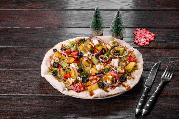 Gustosa insalata fresca preparata per la tavola di Natale. Preparazione della tavola festiva