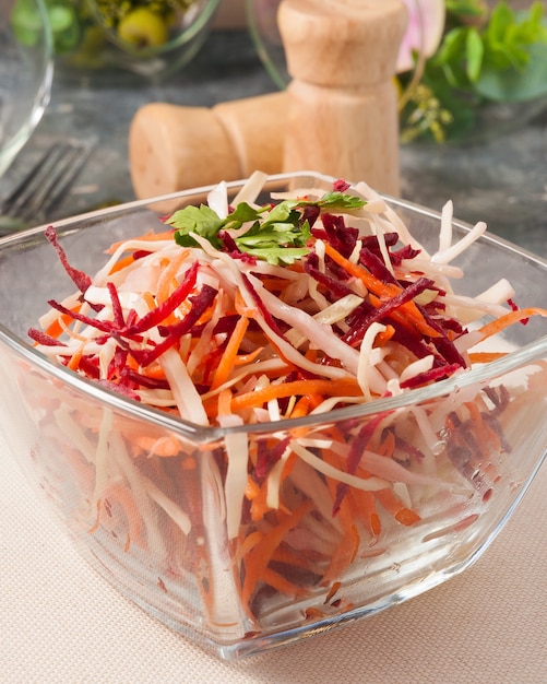 Gustosa insalata primaverile con carota di barbabietola cavolo cappuccio in una ciotola di vetro