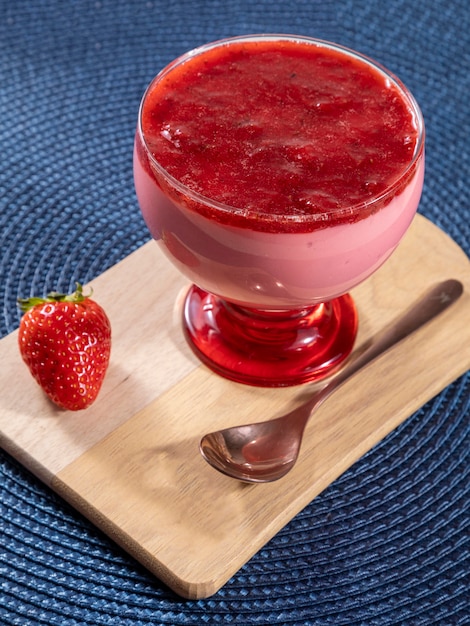 Gustosa mousse di fragole in vetro con sopra marmellata.