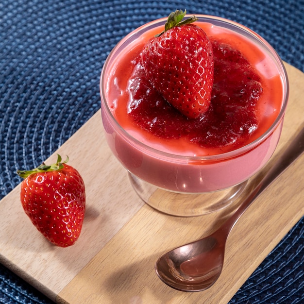 Gustosa mousse di fragole in vetro con sopra marmellata.