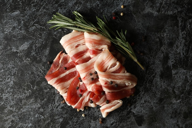 Gustosa pancetta e spezie sulla superficie nera affumicata