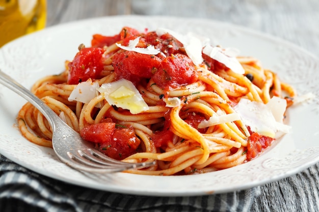 Gustosa pasta italiana classica con salsa di pomodoro e formaggio sul piatto. Avvicinamento.