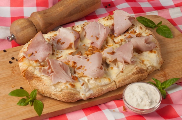 Gustosa pizza a base di crema con prosciutto e funghi