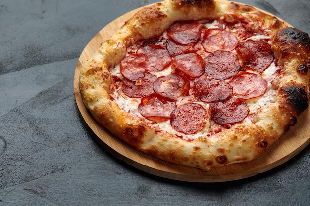 Gustosa pizza ai peperoni su sfondo di cemento nero Vista dall'alto della pizza ai peperoni calda con spazio per la copia per il testo