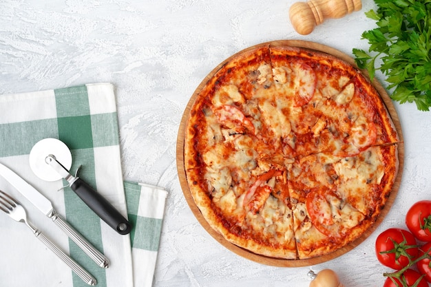 Gustosa pizza con pollo e funghi, vista dall'alto su sfondo grigio