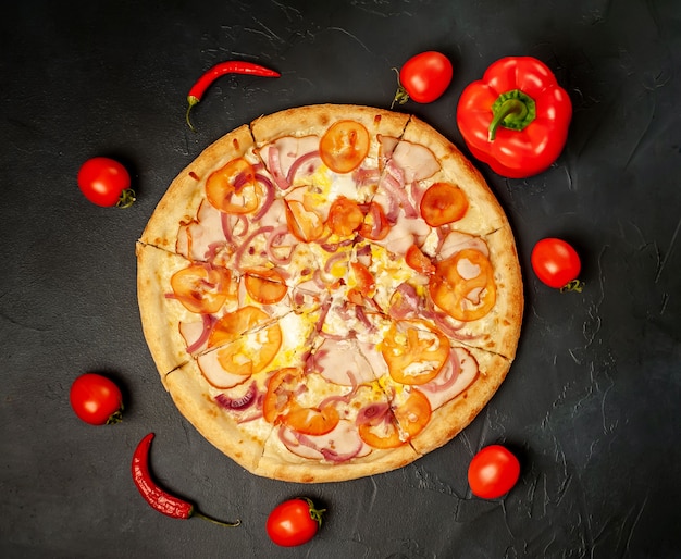 gustosa pizza con prosciutto, pomodoro, peperoncino, salsa di pomodoro, mozzarella su uno sfondo di pietra