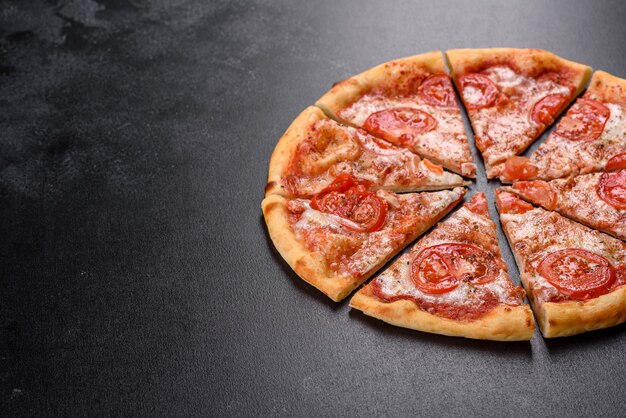 Gustosa pizza fresca al forno con pomodoro, formaggio e basilico su uno sfondo concreto