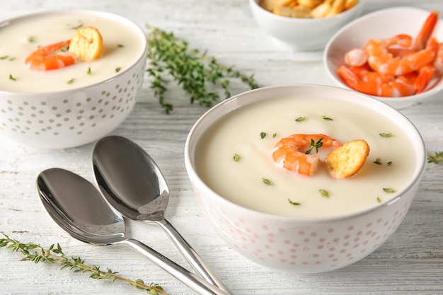 Gustosa zuppa di crema con gamberi in una ciotola sul tavolo