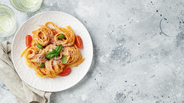 Gustose e appetitose tagliatelle italiane classiche con salsa di pomodoro formaggio parmigiano e basilico su piatto su tavolo luminoso Vista dall'alto orizzontale Vista dall'alto con spazio per la copia