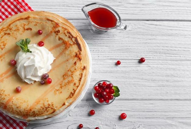 Gustose frittelle con panna e frutti di bosco sul tavolo