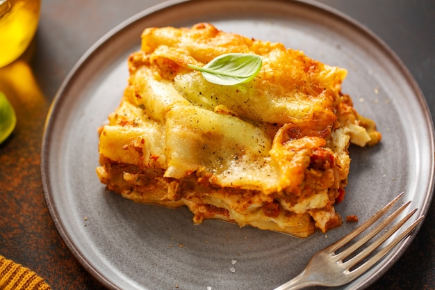 Gustose lasagne italiane preparate al forno classiche in casseruola su sfondo luminoso. Avvicinamento