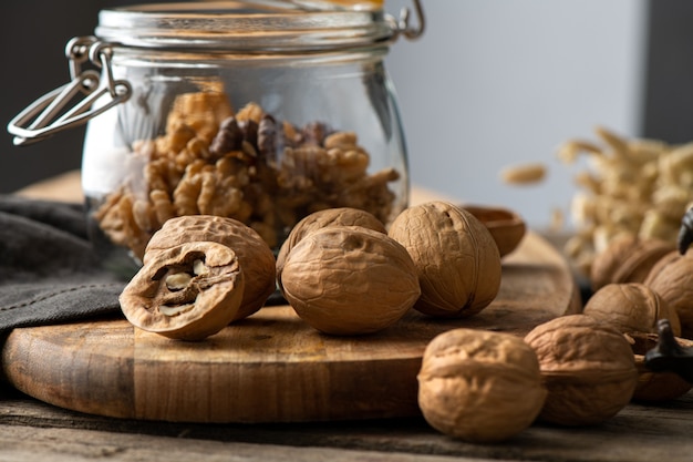 Gustose noci con gusci di noce spaccati incrinati, mascella e schiaccianoci drago su tovagliolo rustico e tavolo in legno wood