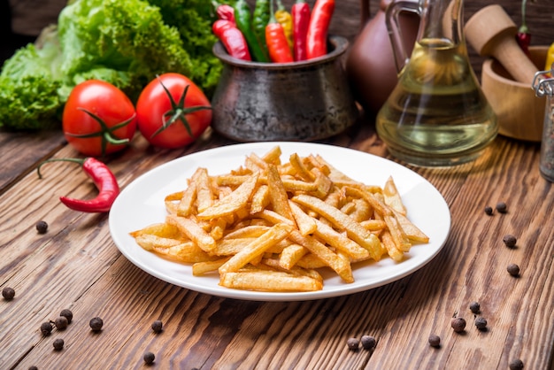 Gustose patatine fritte sul tagliere, tavolo in legno