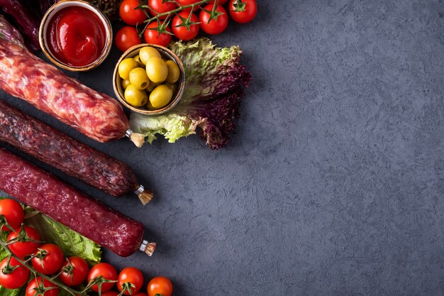 Gustose salsicce di salame con verdure e spezie. Sfondo di salsicce di salame. Vista dall'alto. Copia spazio