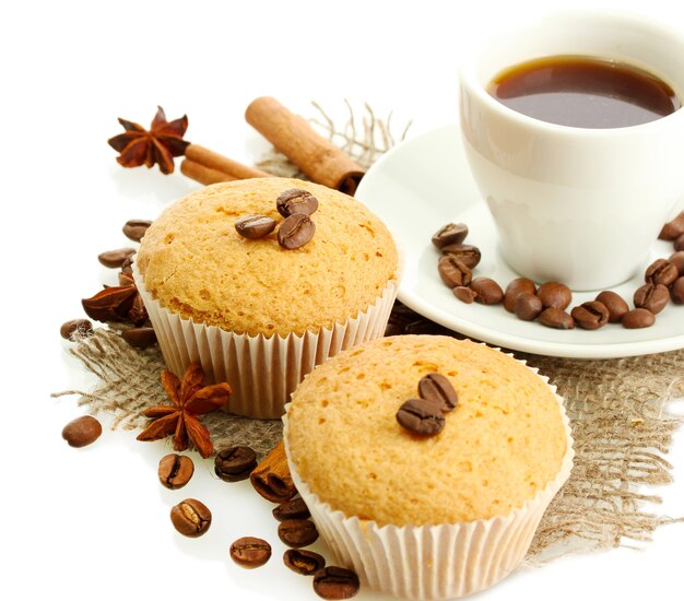 Gustose torte di muffin con spezie su tela e tazza di caffè, isolate su bianco