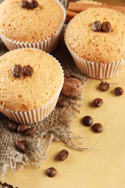 Gustose torte di muffin su tela, spezie e semi di caffè, su fondo beige