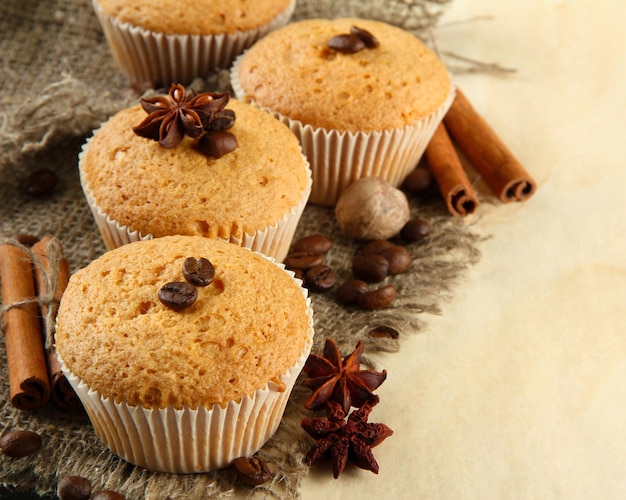 Gustose torte di muffin su tela, spezie e semi di caffè, su fondo beige