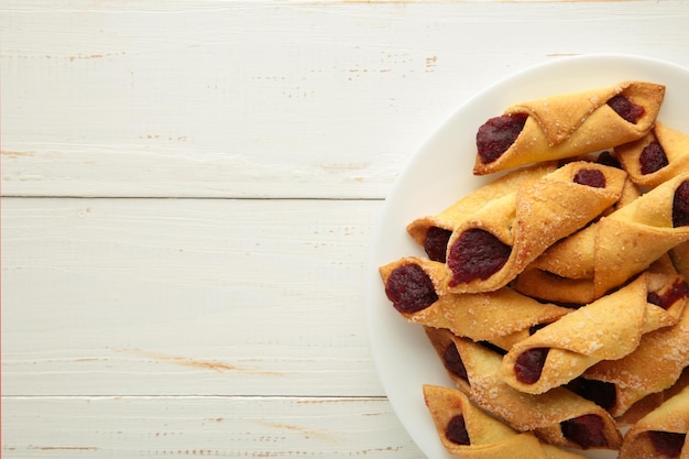 Gustosi bagel con marmellata di fragole su fondo di legno bianco Biscotti fatti in casa