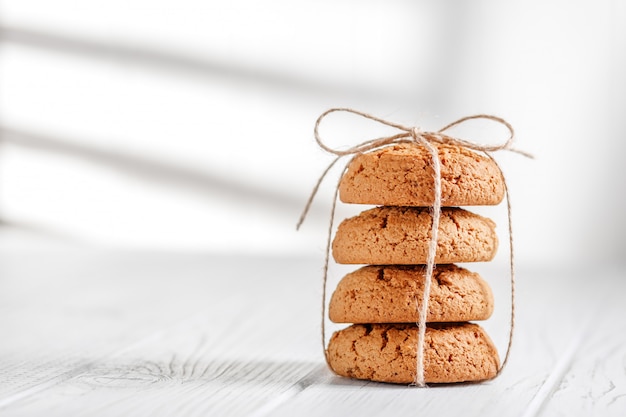 Gustosi biscotti di farina d&#39;avena utili su un tavolo bianco.