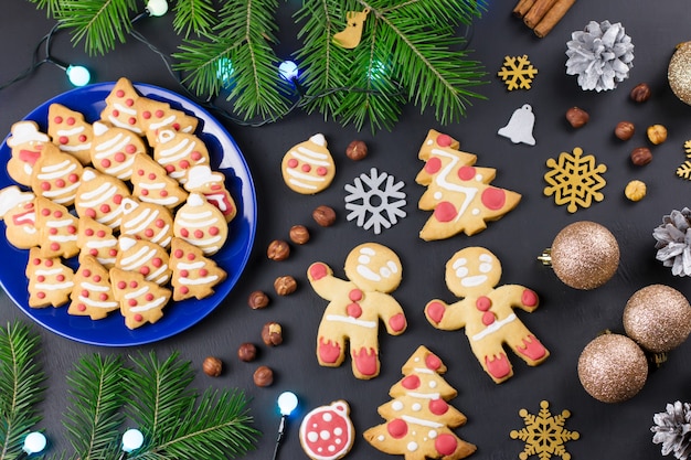 Gustosi biscotti di Natale, albero di Natale, decorazioni su sfondo nero. Natale concetto di cucina. Vista dall'alto