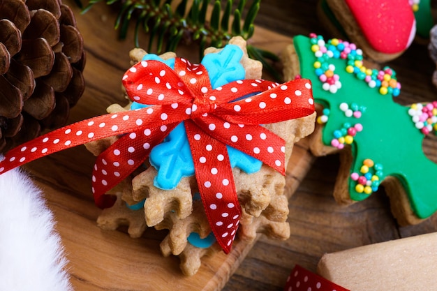 Gustosi biscotti di Natale regalo commestibile rami di abete coni su fondo di legno si chiuda