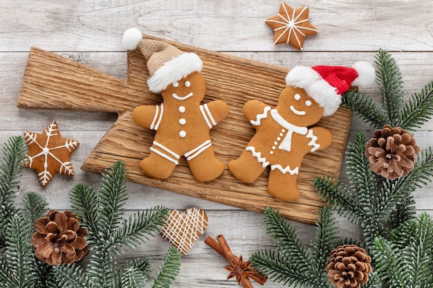 Gustosi biscotti di panpepato e decorazioni natalizie su fondo di legno.