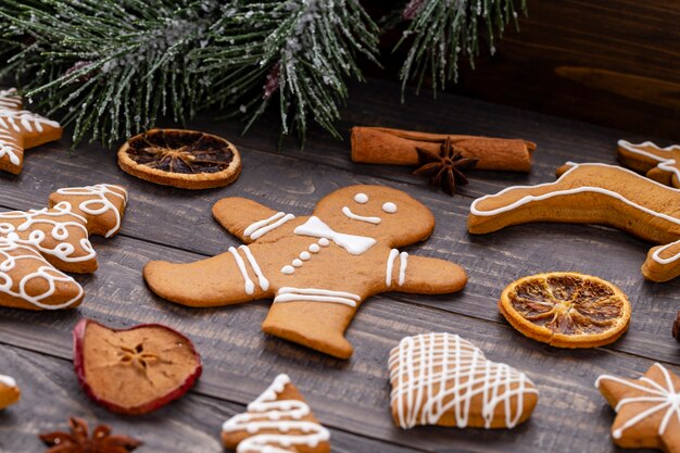 Gustosi biscotti di panpepato e decorazioni natalizie su fondo di legno.