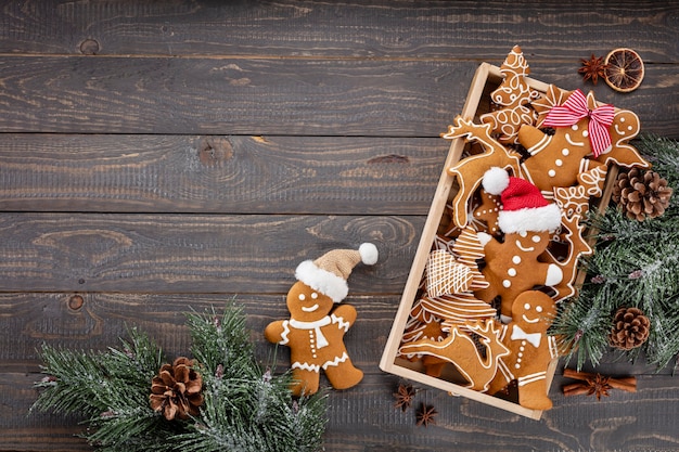 Gustosi biscotti di panpepato e decorazioni natalizie su fondo di legno.