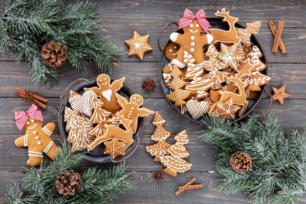 Gustosi biscotti di panpepato e decorazioni natalizie su fondo di legno.