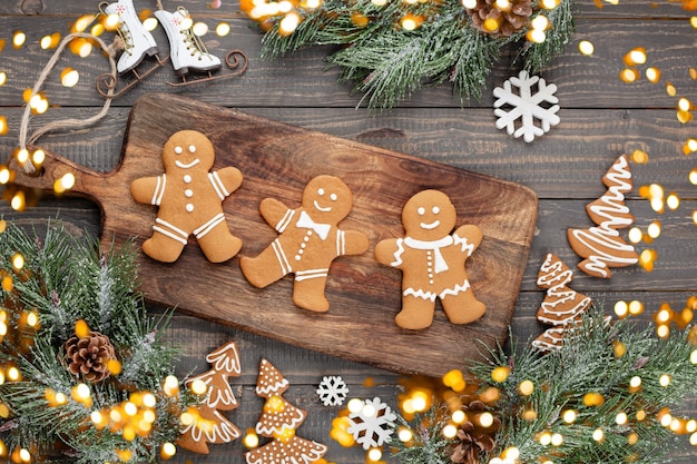 Gustosi biscotti di panpepato e decorazioni natalizie su fondo di legno.