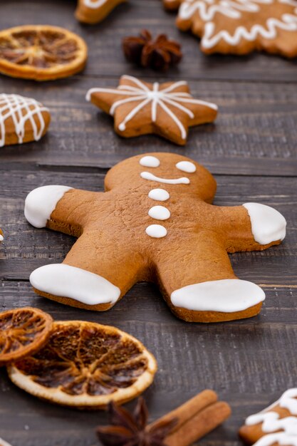 Gustosi biscotti di panpepato e decorazioni natalizie su fondo di legno.