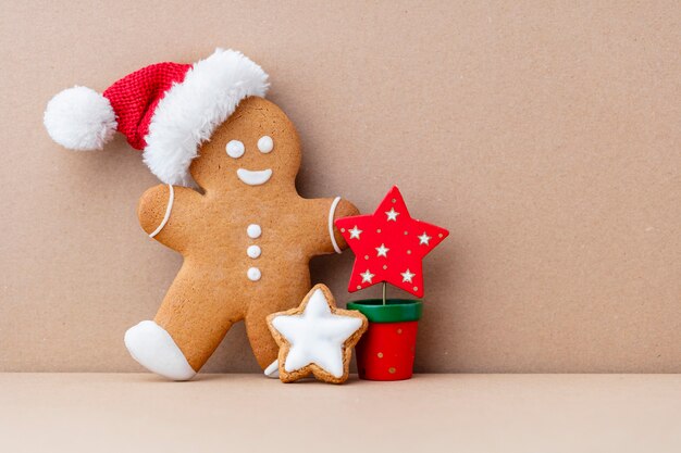 Gustosi biscotti di panpepato e decorazioni natalizie su sfondo pastello.