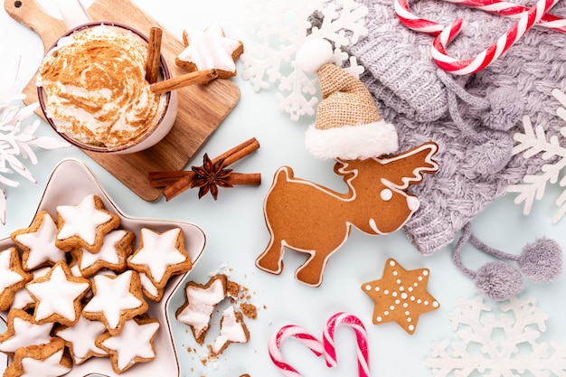 Gustosi biscotti di panpepato e decorazioni natalizie su sfondo pastello.