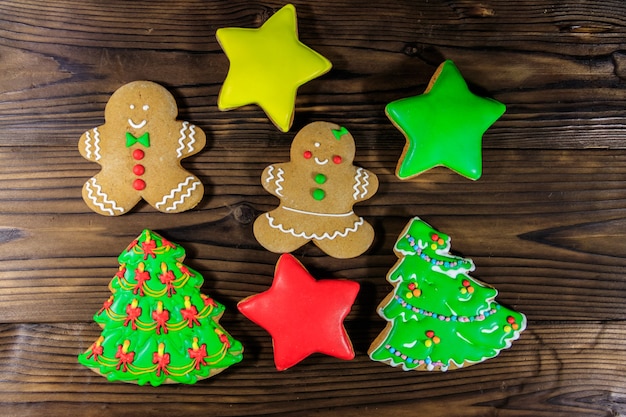Gustosi biscotti di panpepato natalizio a forma di albero di Natale, uomini di panpepato e stelle su un tavolo di legno. Vista dall'alto
