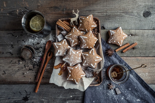 Gustosi biscotti fatti in casa con cucchiai di spezie e caramelle ricce sdraiate su un tavolo di legno