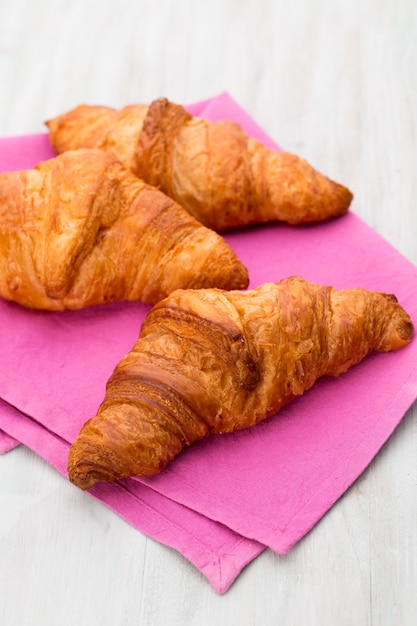 Gustosi croissant burrosi sul vecchio tavolo in legno.