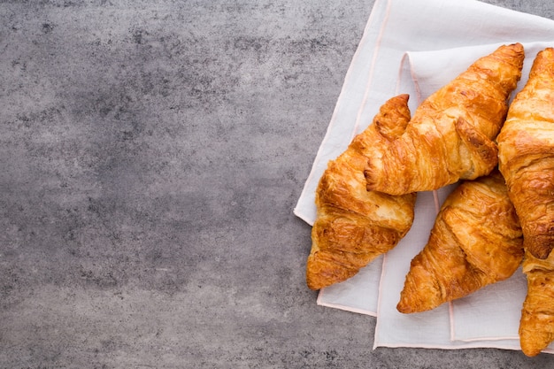 Gustosi croissant burrosi sul vecchio tavolo in legno.