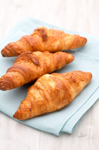 Gustosi croissant burrosi sul vecchio tavolo in legno.