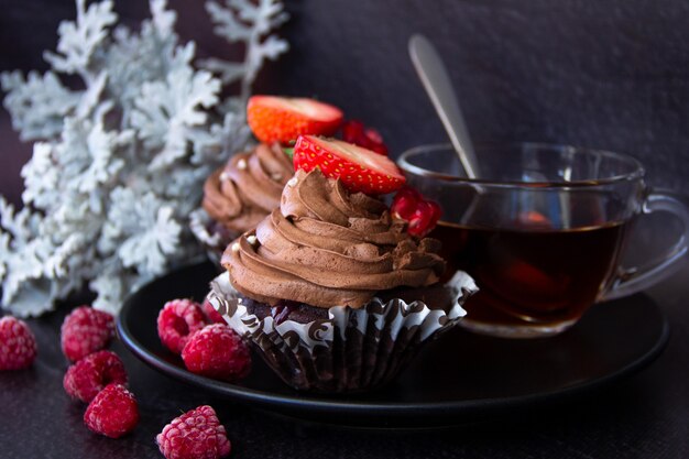 Gustosi cupcakes al cioccolato con fragole e una tazza di tè