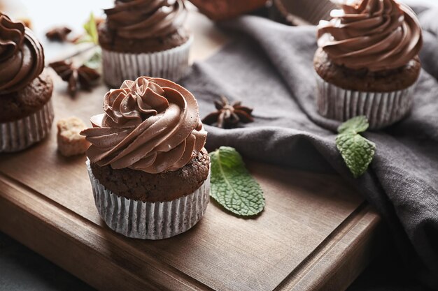Gustosi cupcakes al cioccolato su tavola di legno
