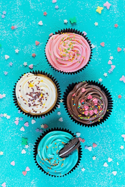 Gustosi cupcakes colorati isolati sull'azzurro