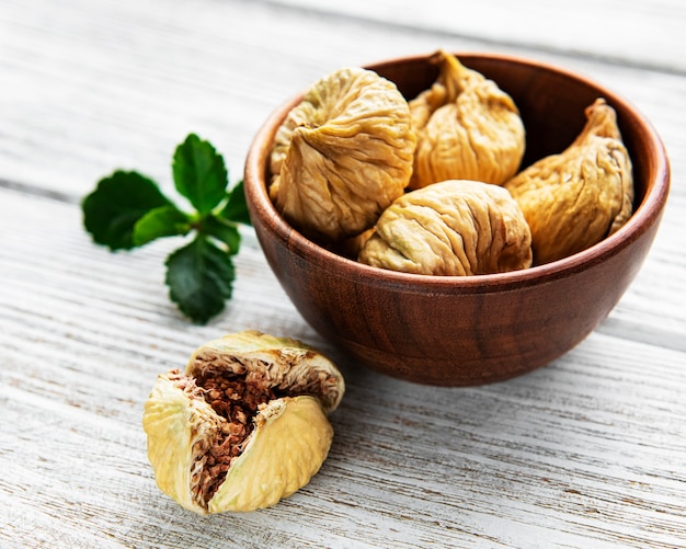 Gustosi fichi secchi in una ciotola su un tavolo di legno bianco