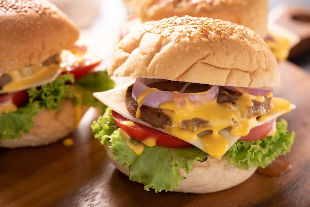 Gustosi hamburger fatti in casa alla griglia con carne di manzo, pomodoro, formaggio, cetrioli e lattuga