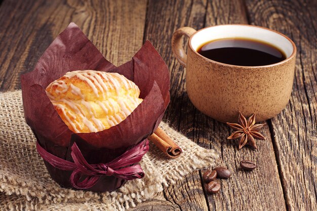 Gustosi muffin e tazza di caffè sulla tavola di legno d'epoca