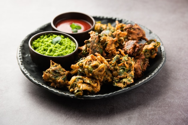 Gustosi Palak pakoda o pakora fatti in casa noti come Spinaci Firtters, serviti con ketchup. Spuntino preferito per l'ora del tè dall'India