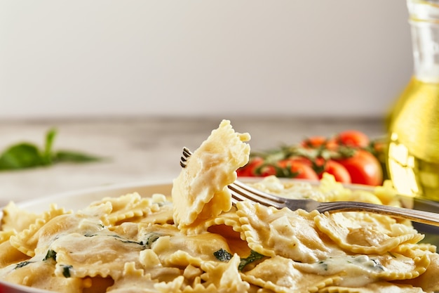 Gustosi ravioli cotti con salsa di panna, pomodorini, olio di semi di girasole e basilico