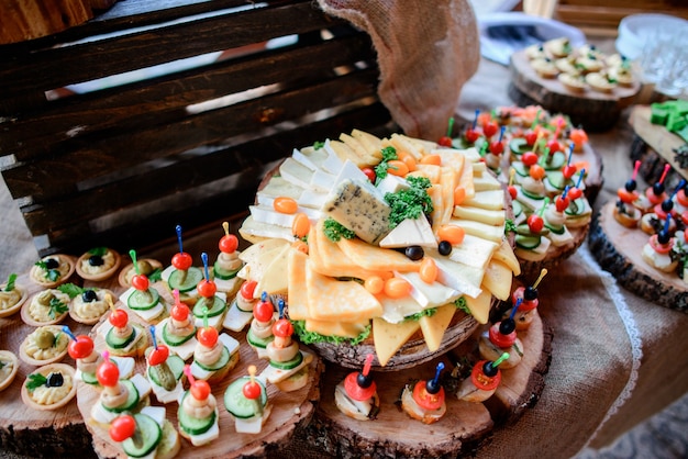 Gustosi spuntini di formaggio, olive e verdure sottaceto servite su piatti di legno